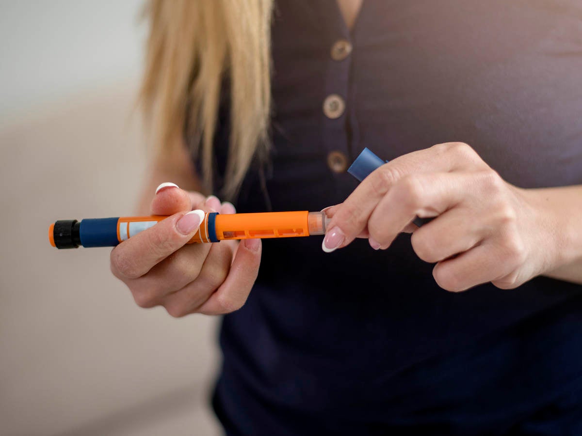 woman holding insulin injector pen